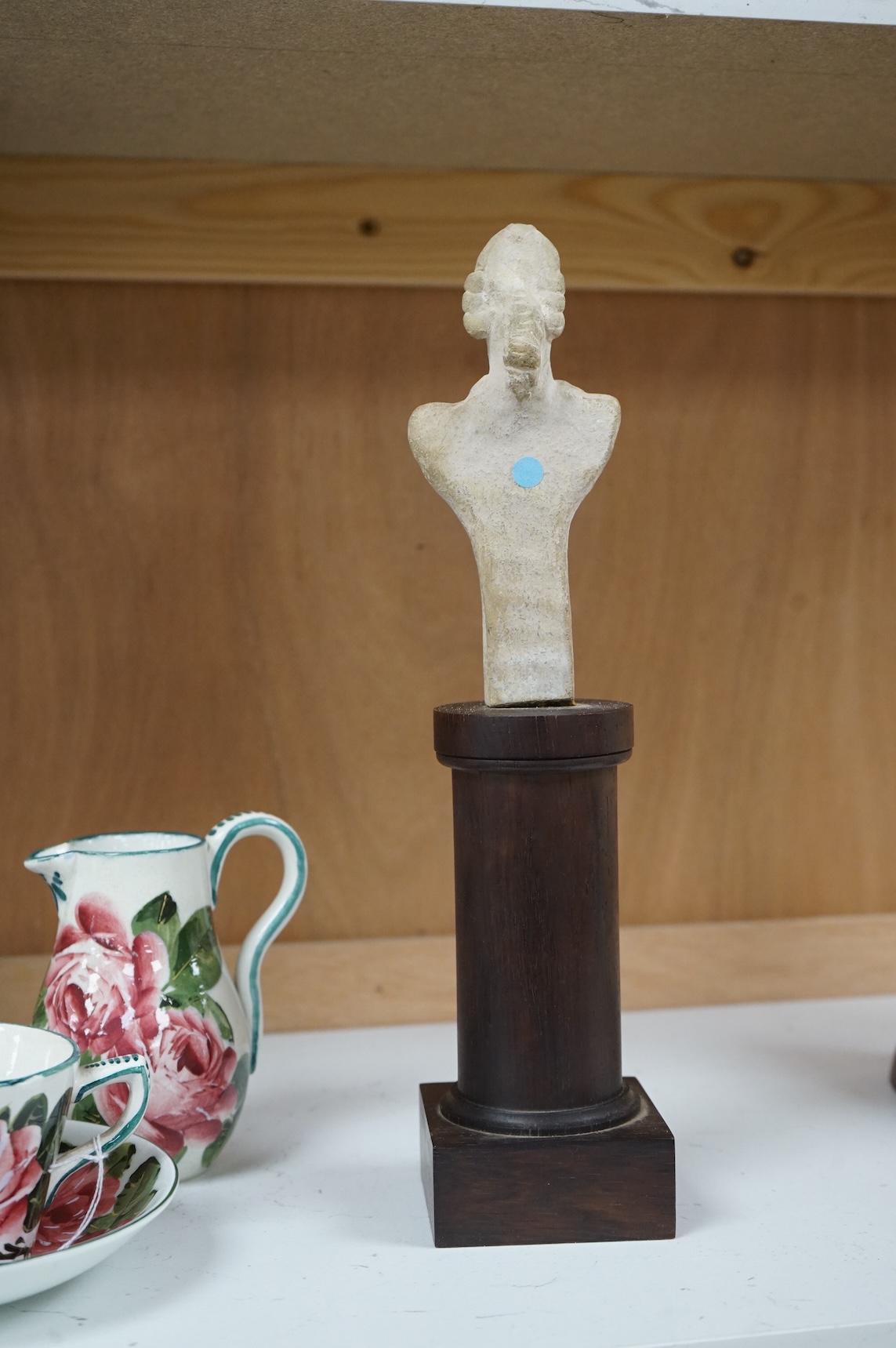 A Syro-Hittite pottery figure, on columnar rosewood stand, 29cm high